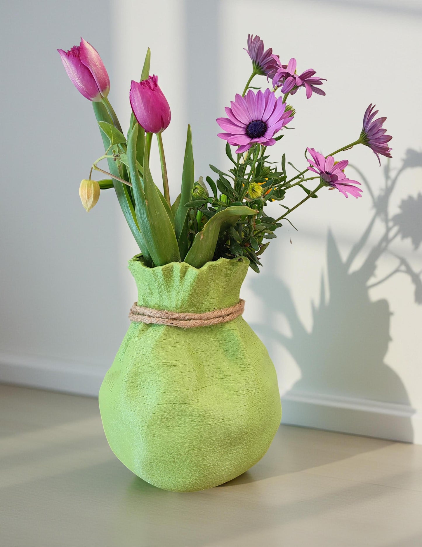 Modern, whimsical, pastel green vase in the shape of a bag.