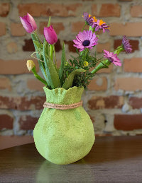 Modern, whimsical, pastel green vase in the shape of a bag.