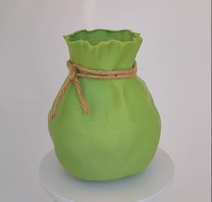 Modern, whimsical, pastel green vase in the shape of a bag.