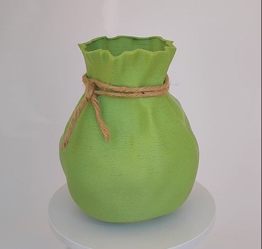 Modern, whimsical, pastel green vase in the shape of a bag.
